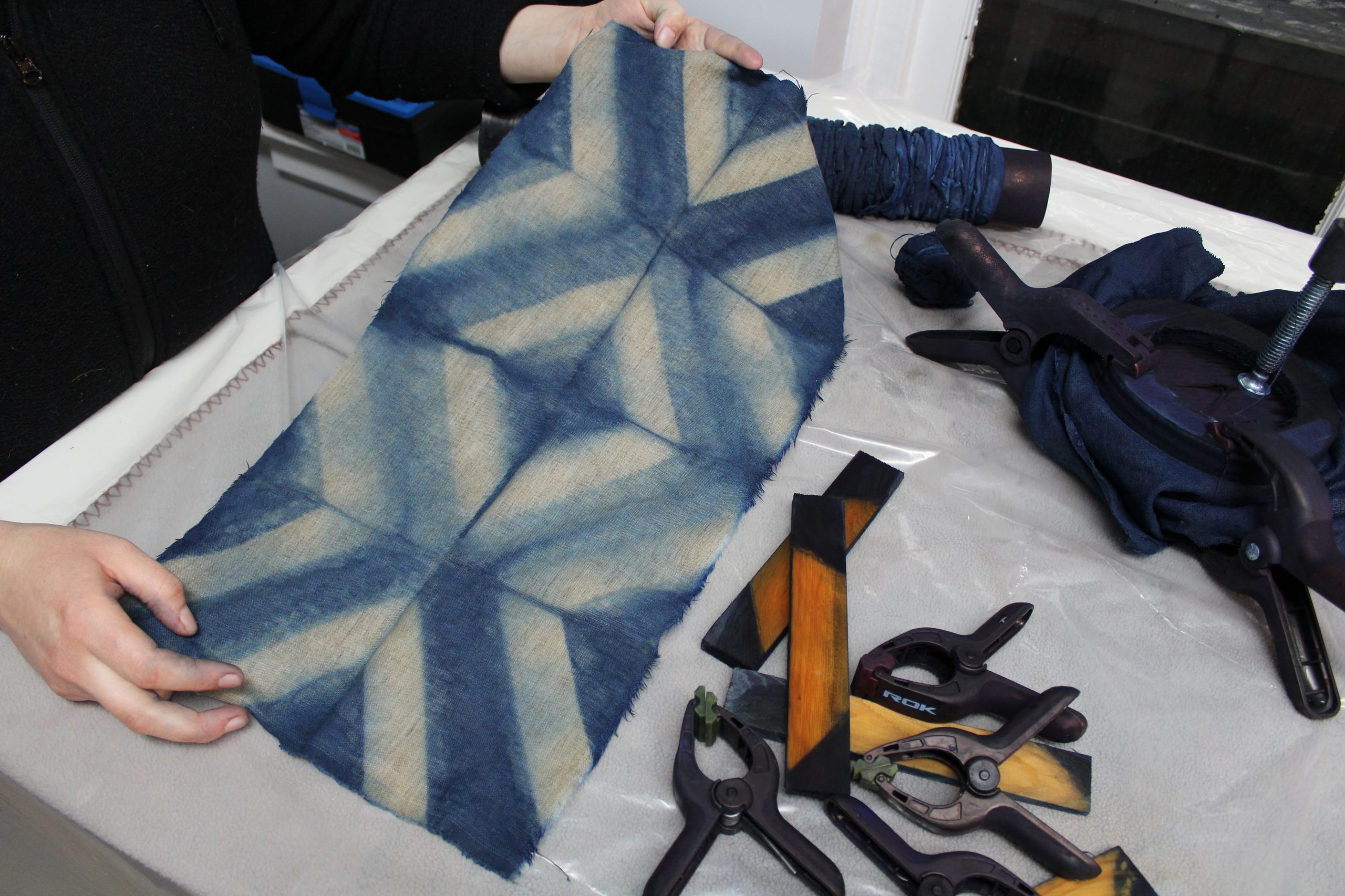 Process photo of Josie Clarke unfolding a dyed textile